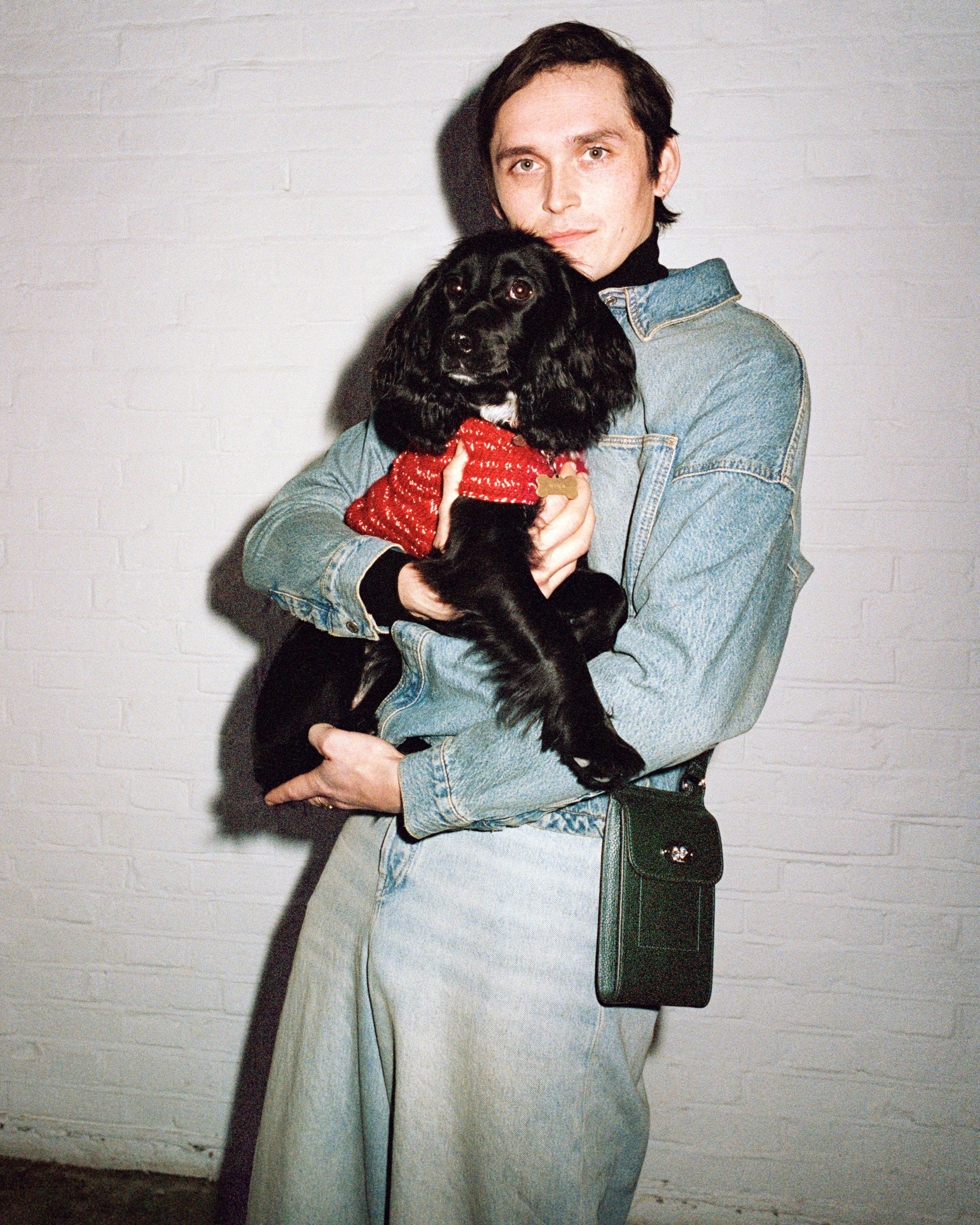 Model hält einen Hund und trägt die Mulberry Mini Antony Tasche aus grünem Leder